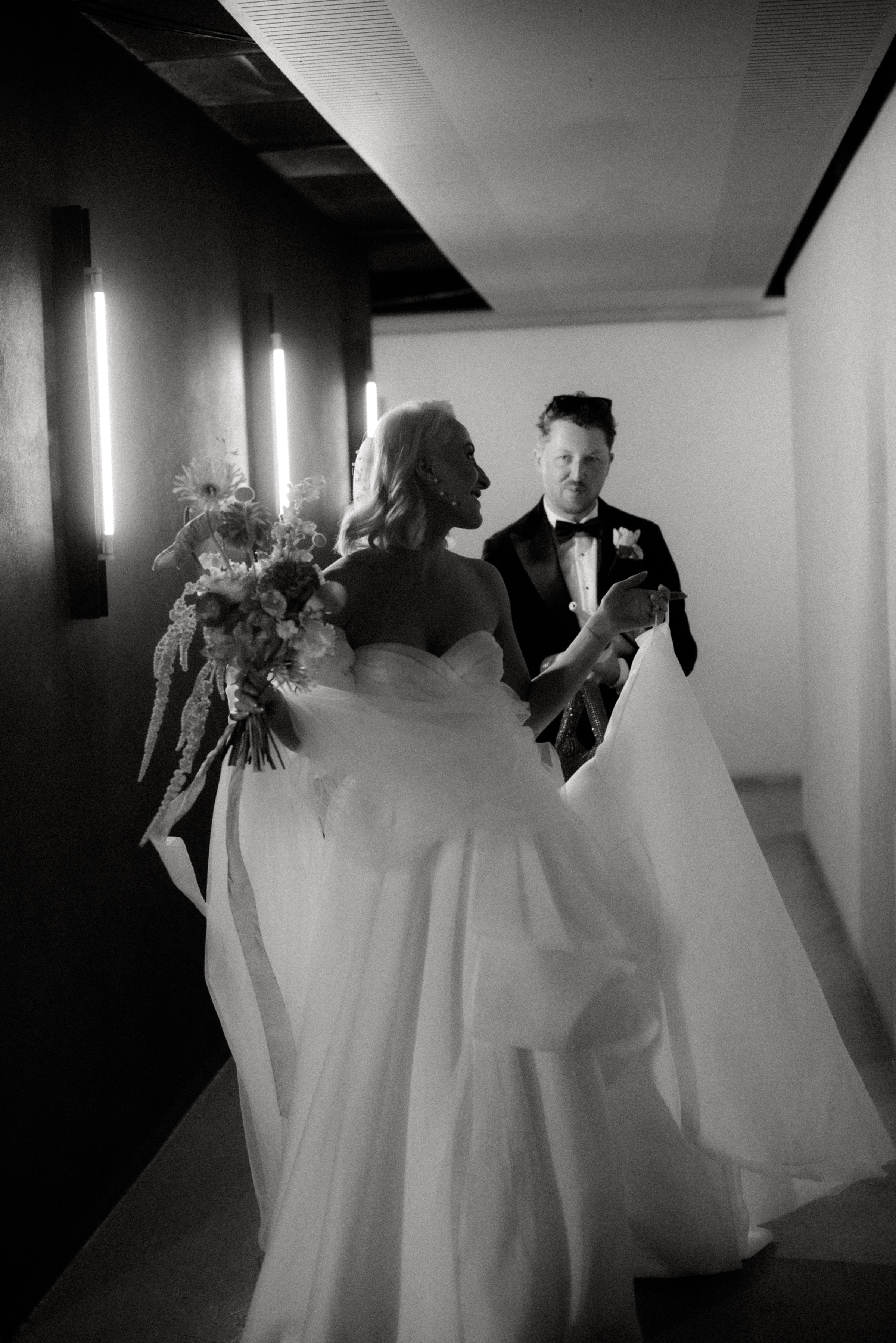 A black and white photo of a bride and groom leaving their Air BnB to take photos in the streets en route to their wedding ceremony at Glasshaus Outside in Richmond, Melbourne.